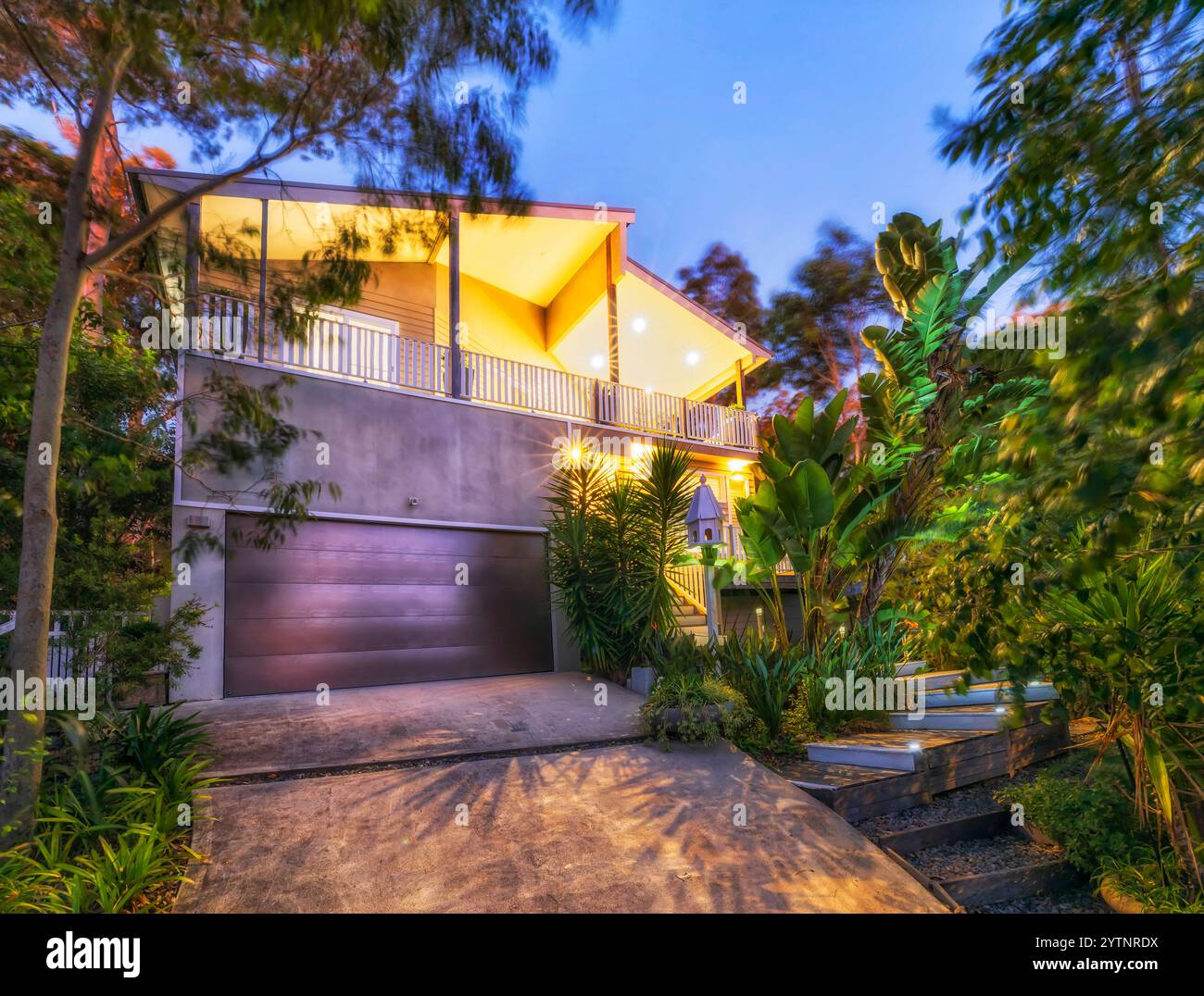 Fassade des luxuriösen Kurzaufenthalt-Familienziels bei Sonnenuntergang mit Lichtern am Murrays Strand am Lake Macquarie. Stockfoto