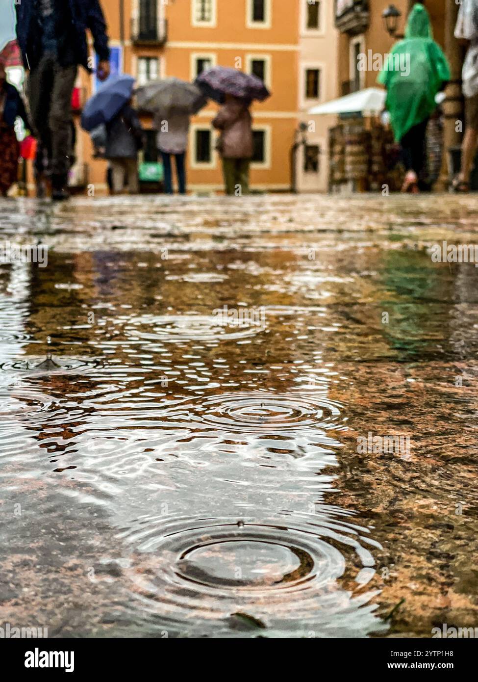 Reflexionen in Pfützen nach Niederschlägen während des Santa Tecla Festivals in Tarragona, Barcelona, Spanien - Smartphone-aufgenommenes Stockfoto