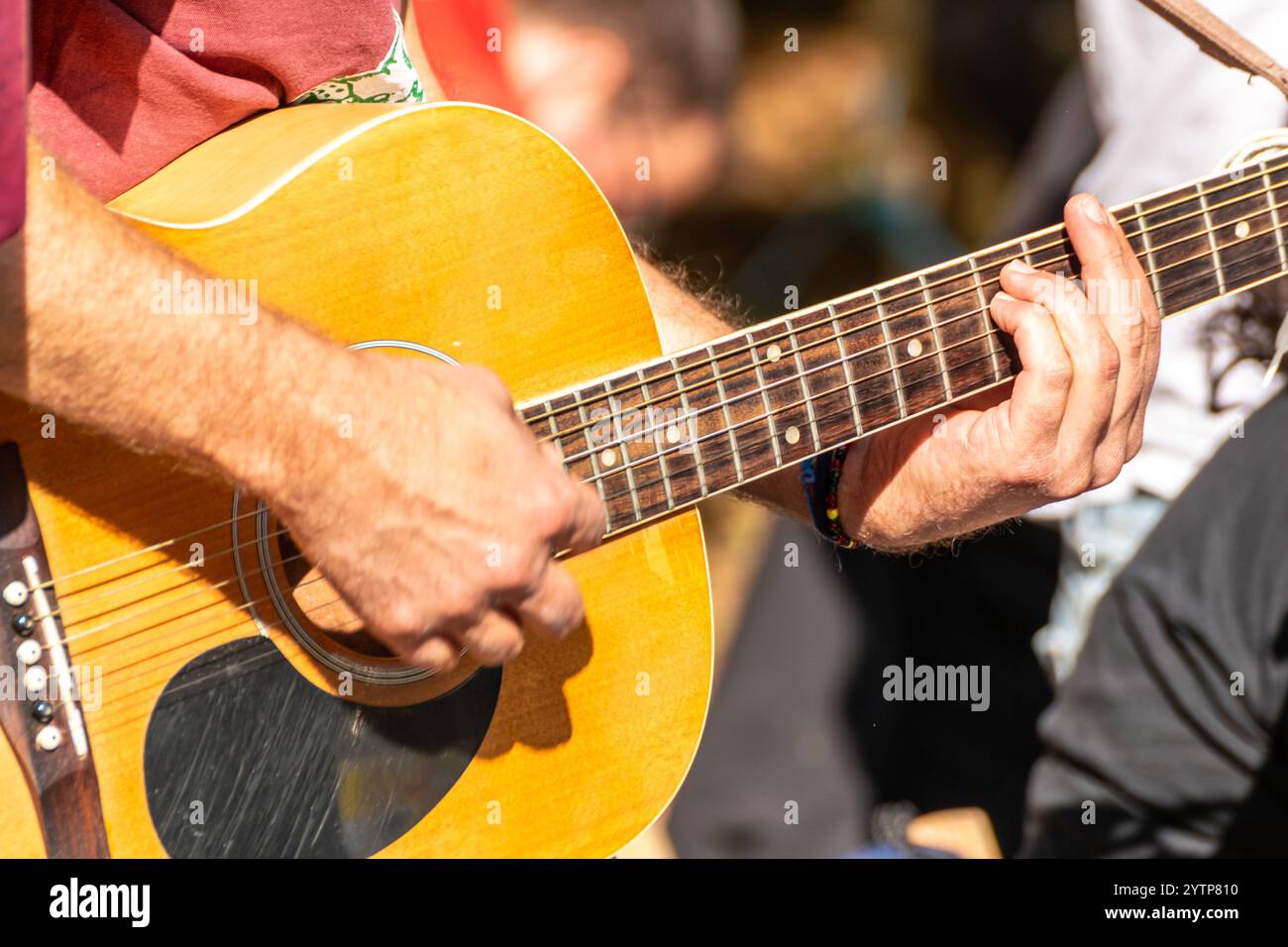 Nahaufnahme der Hand des Gitarristen am Griffbrett, eines Mannes, der bei einem Outdoor-Event spanische Gitarre spielt Stockfoto