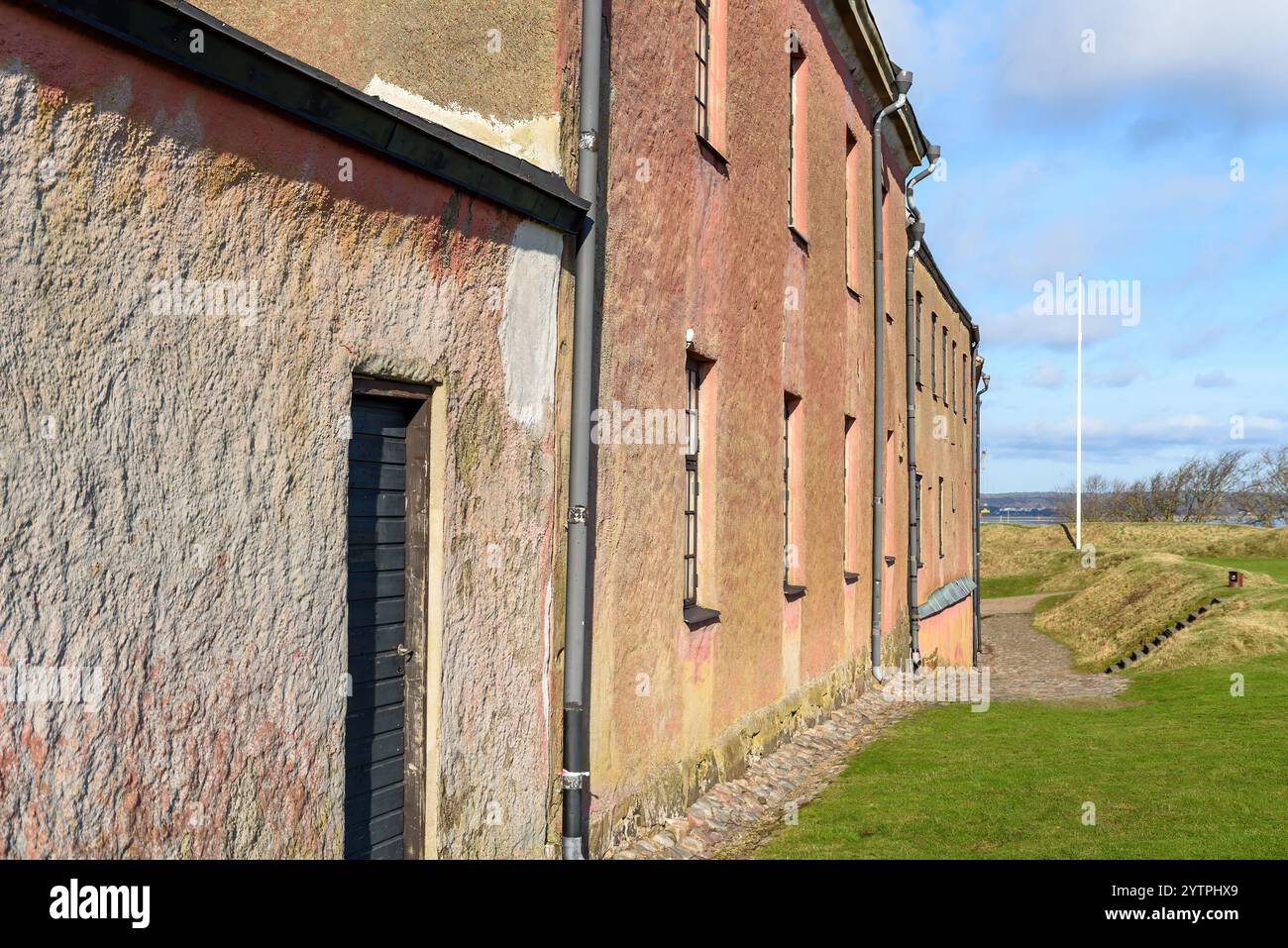 Die Struktur verfügt über eine interessante Mischung aus Texturen und Farben, mit einer gut erhaltenen Fassade. Das Gebäude ist von Gras bedeckt, Highlight Stockfoto