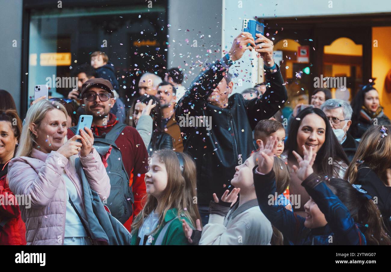 Das Bild zeigt eine Gruppe von Personen, die sich in einer öffentlichen Umgebung versammelt haben. Sie schauen in die gleiche Richtung, einige mit Stockfoto