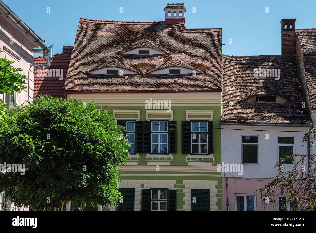 Ein gekacheltes Dach mit traditionellen Dachfenstern in Augenform, Sibiu, Siebenbürgen, Rumänien Stockfoto