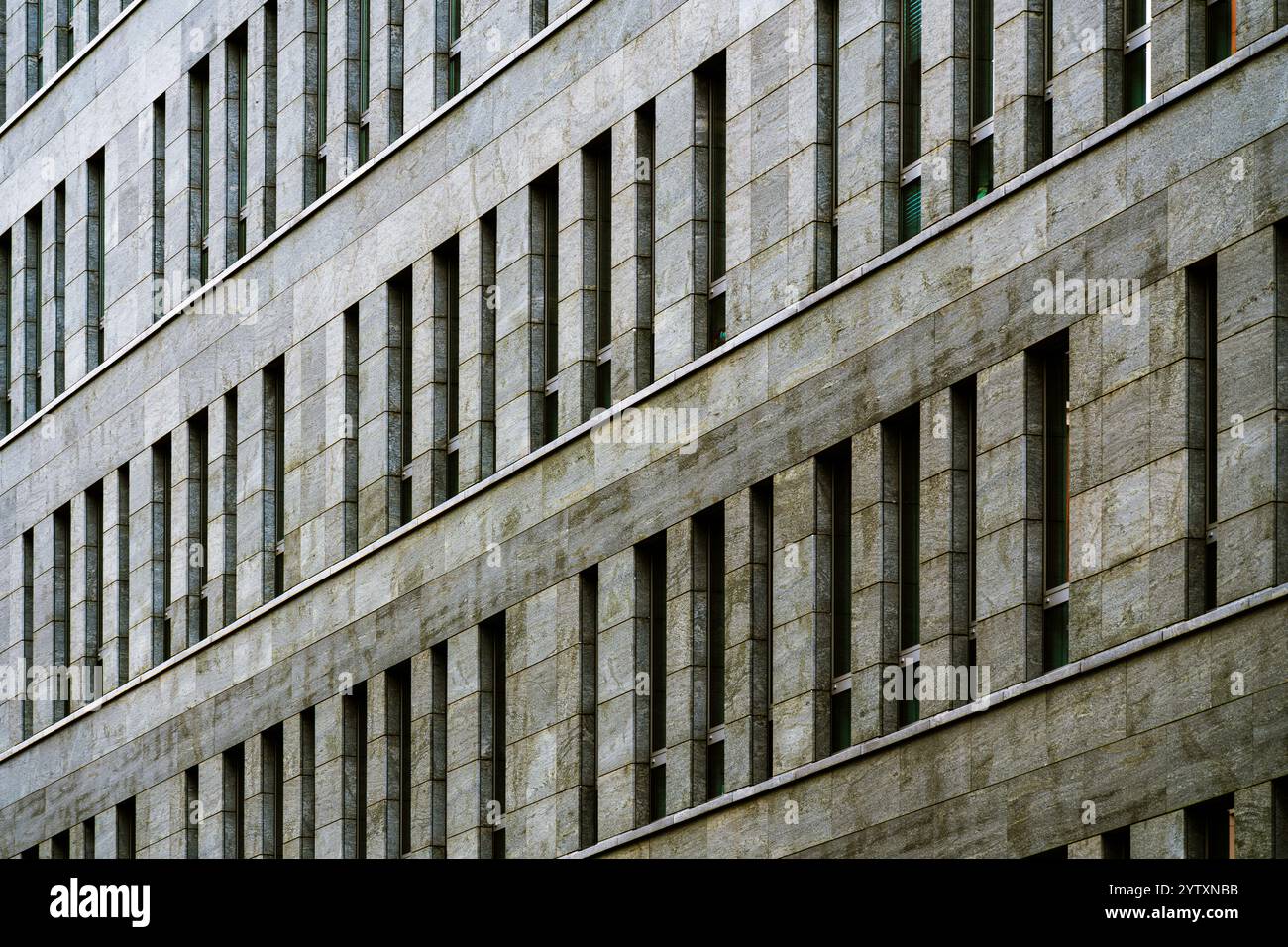 Moderne Fassade des Bürogebäudes mit sich wiederholenden Fenstern und Steinen Stockfoto