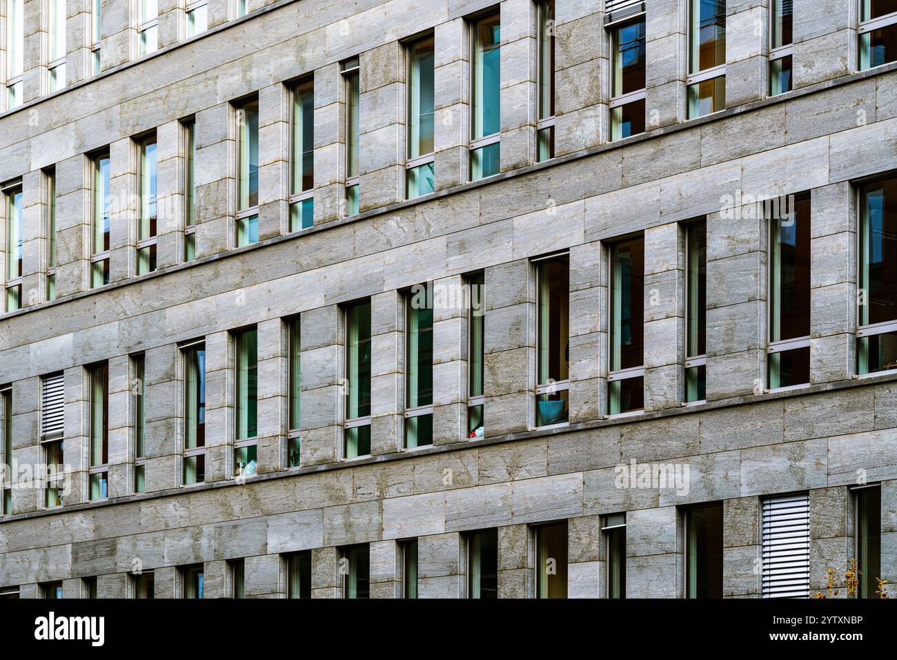 Moderne Fassade des Bürogebäudes mit sich wiederholenden Fenstern und Steinen Stockfoto