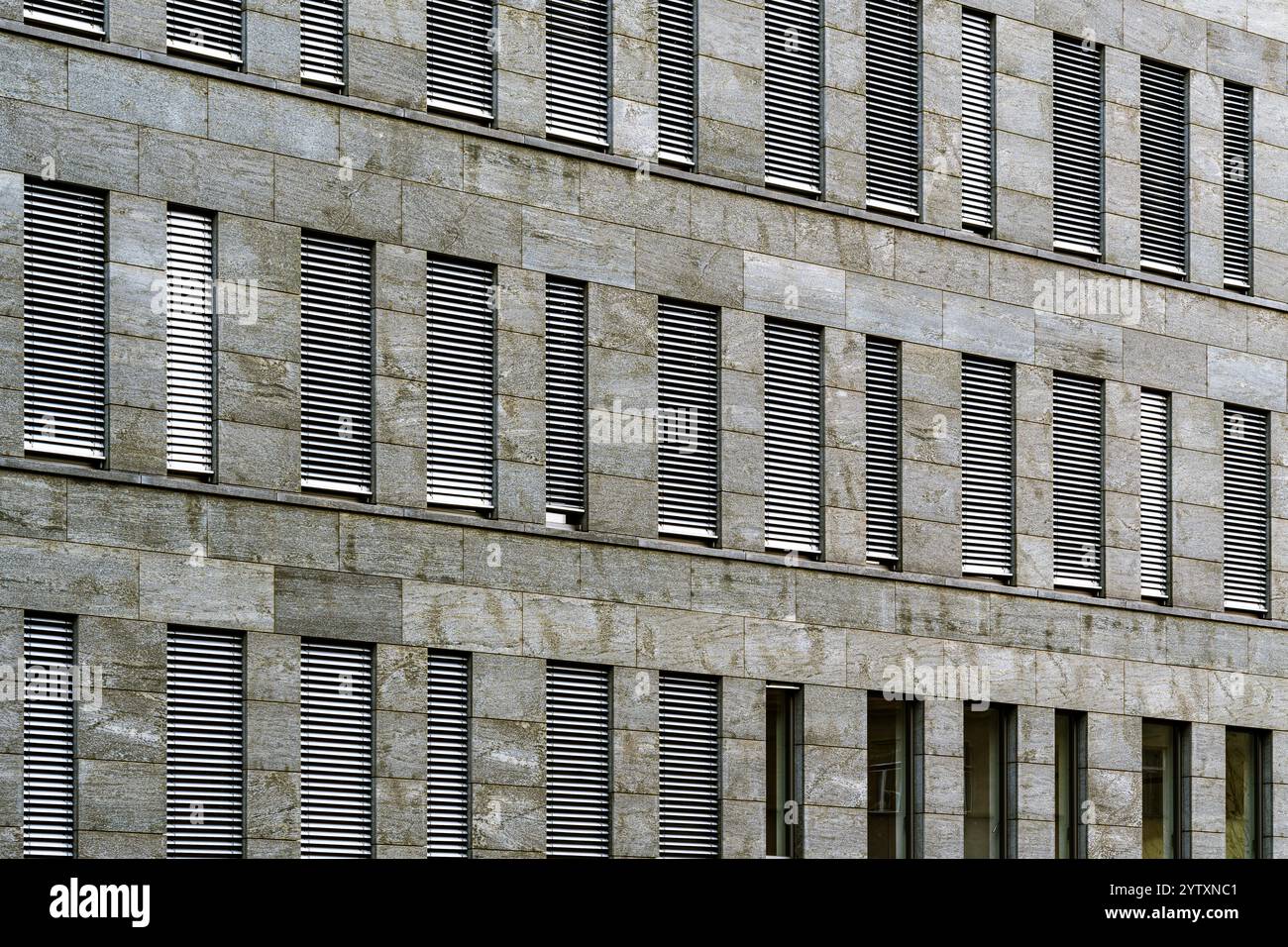 Moderne Fassade des Bürogebäudes mit sich wiederholenden Fenstern und Steinen Stockfoto