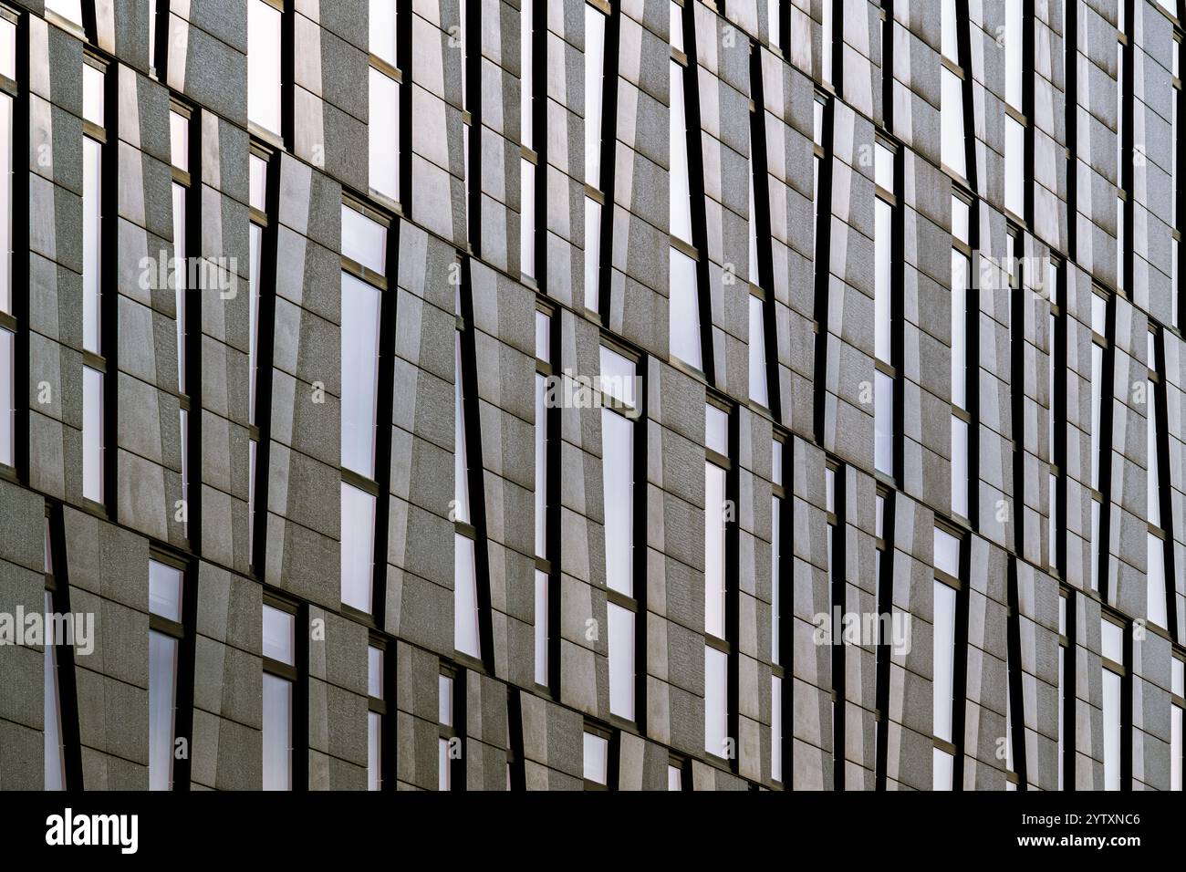 Moderne Fassade des Bürogebäudes mit sich wiederholenden Fenstern und Steinen Stockfoto