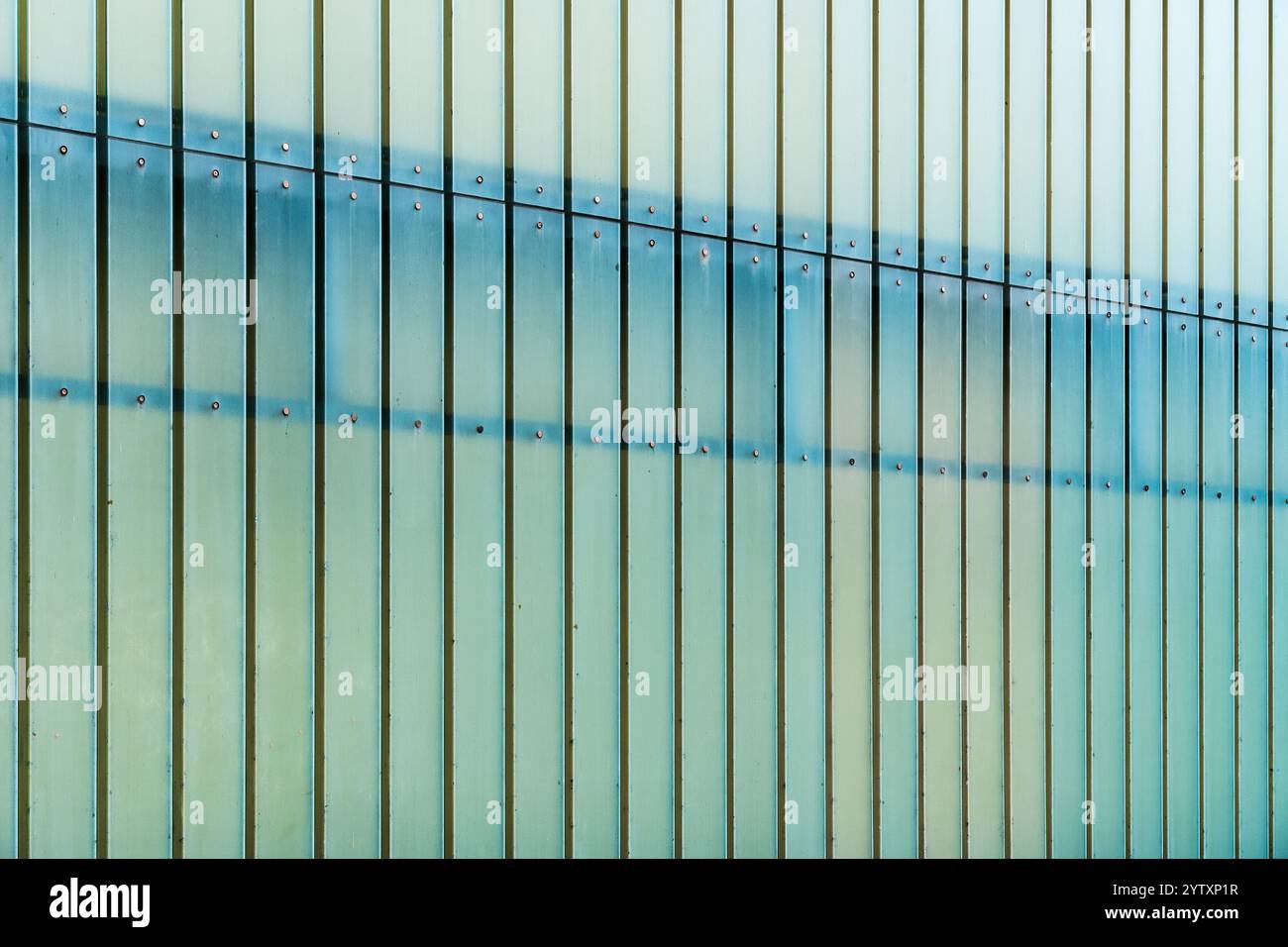 Moderne Glasfassade mit vertikalen Paneelen und dezentem grünem Farbverlauf Stockfoto