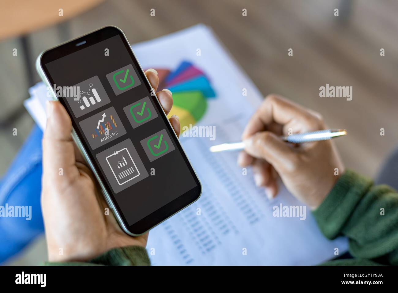 Mithilfe eines mobilen Smartphones arbeitet Geschäftsfrau mit Bilanzbuchhaltung für die Kalkulation von Finanzen, Steuern, Buchhaltung, Statistik und Analyse Stockfoto