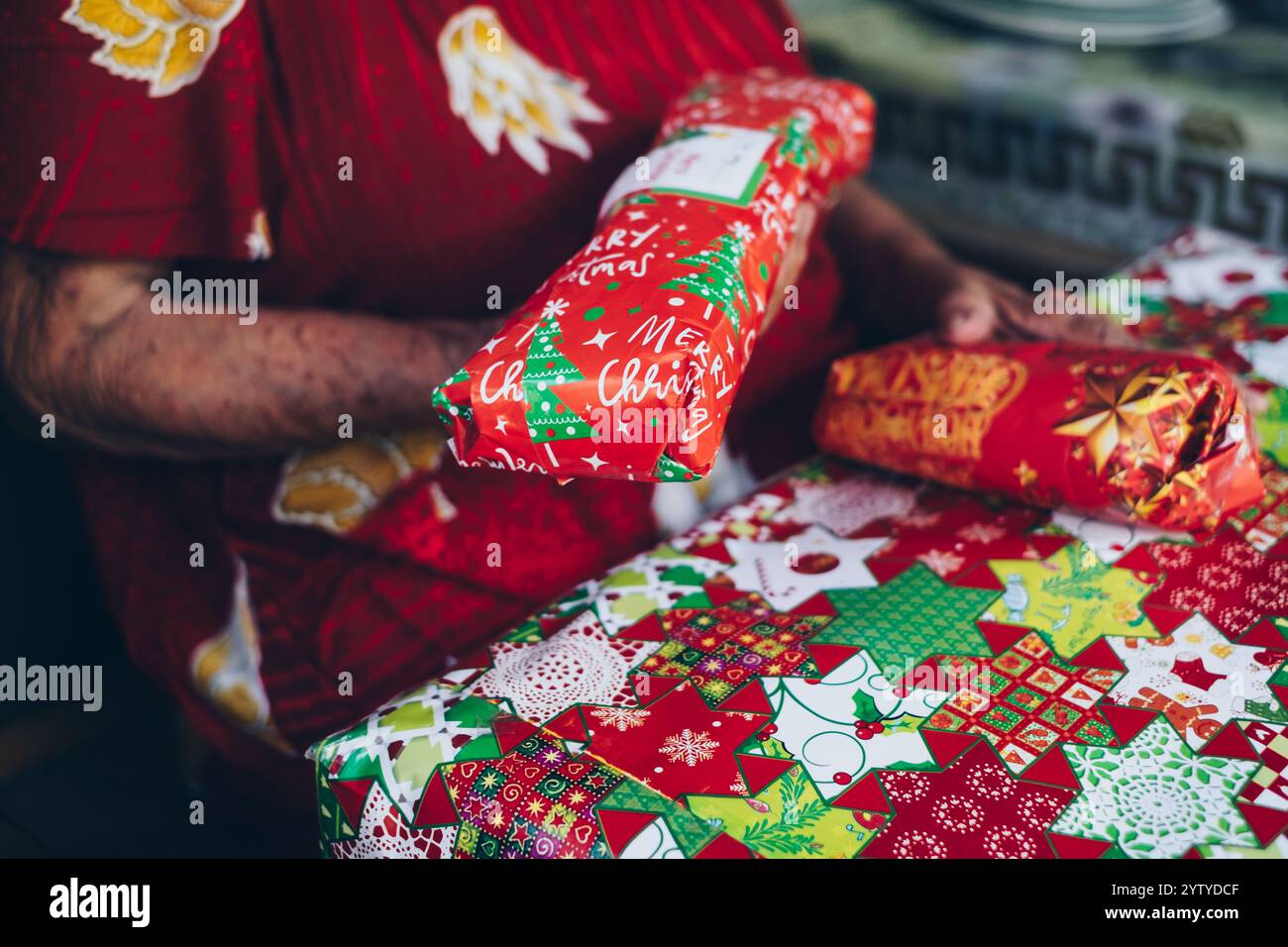 Nahaufnahme einer alten Frau, die drei Weihnachtsgeschenke hielt. Selektiver Fokus. Stockfoto