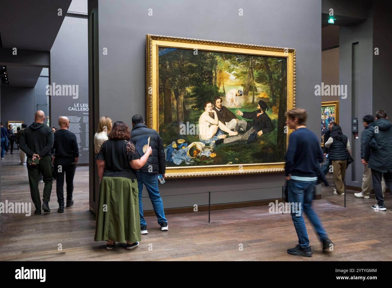 Besucher sehen Le Déjeuner sur l'herbe von Edouard Manet im Musée d'Orsay, Paris. Stockfoto