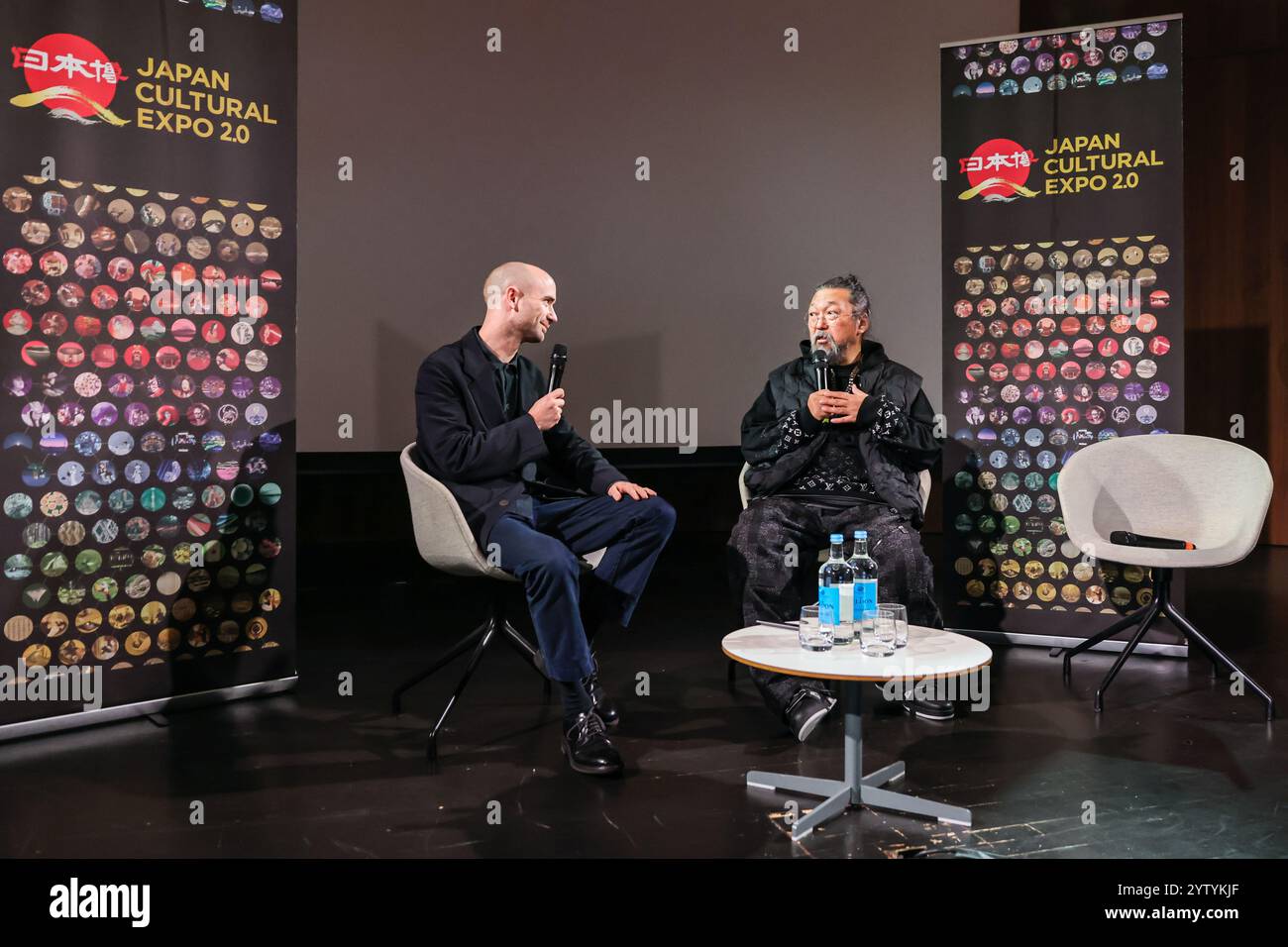 London, Großbritannien. Dezember 2024. Künstler Takashi Murakami mit Sam Thorne, Generaldirektor und CEO von Japan House London beim Interview „im Gespräch mit Sam Thorne“ im V&A Museum in South Kensington, bei seiner ersten öffentlichen Veranstaltung in Großbritannien seit 2018 im Rahmen der Japan Cultural Expo 2,0. Quelle: Imageplotter/Alamy Live News Stockfoto