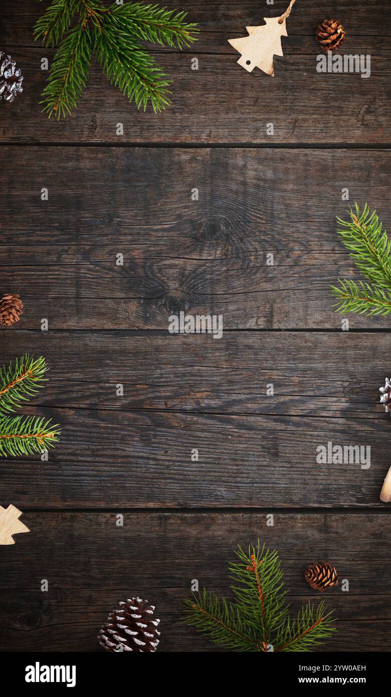 Rustikaler Holztisch mit weihnachtlichen Zweigen und Dekorationen, Flachbild-Draufsicht, leerer Platz für einen Weihnachtsgruß oder eine festliche Botschaft Stockfoto