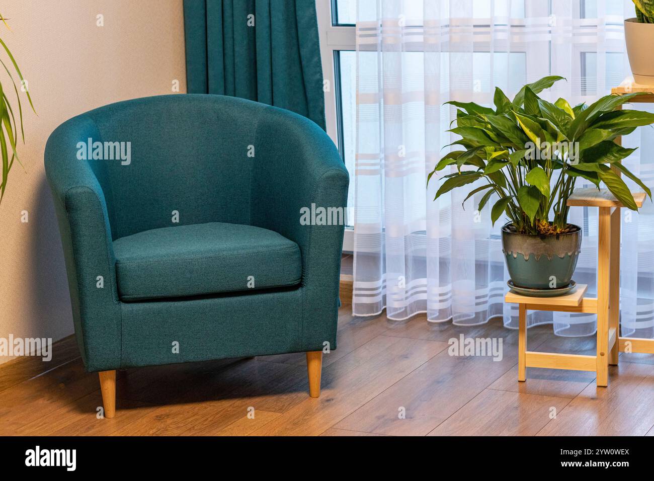Nahaufnahme der gemütlichen Ecke im Apartment mit komfortablem Sessel. Stockfoto