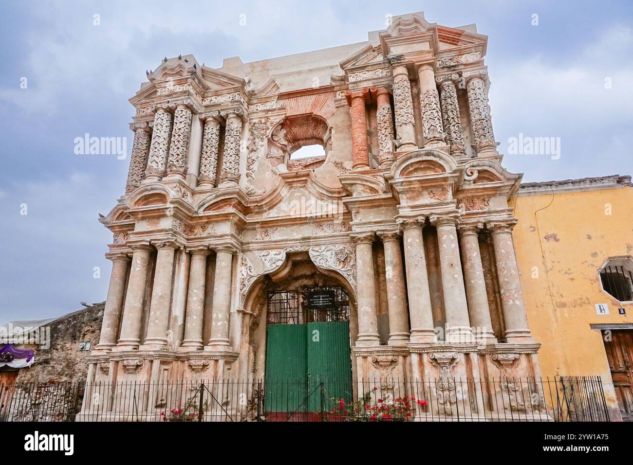 Außenfassade der Ruinen der Iglesia de Nuestra Señora de El Carmen oder der Kirche unserer Lieben Frau von Carmen, einer kunstvollen katholischen Kirche, die 1773 durch die Erdbeben in Santa Marta in Antigua, Guatemala, zerstört wurde. Vor den Ruinen findet oft ein wöchentlicher Kunsthandwerksmarkt statt. Stockfoto