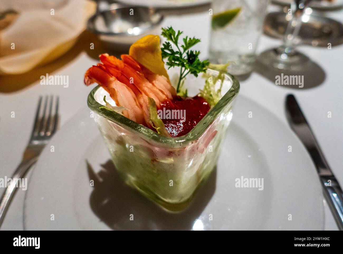 Ein Glas Serviergericht mit Garnelen-Cocktail, mit frischen Garnelen, Salat, Cocktailsauce, einem Zitronenkeil, und Petersilie-Garnitur, elegant präsentiert Stockfoto