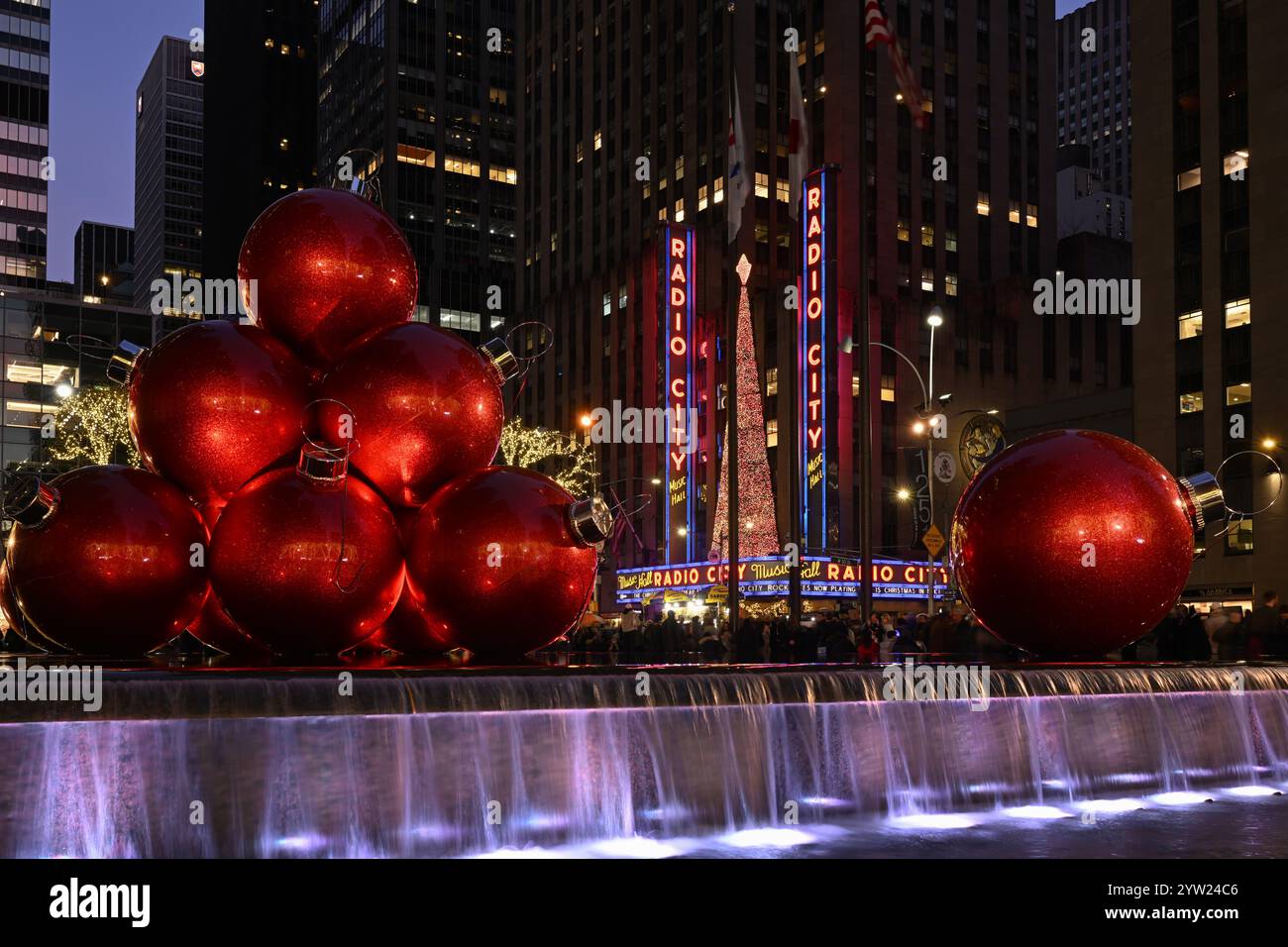 Riesige rote Weihnachtsdekorationen vor dem 1251 Sixth Avenue Gebäude (Exxon Building) gegenüber der Radio City Music Hall am 8. Dezember 2024 in New York CI Stockfoto