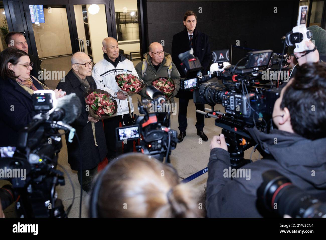 Gardermoen 20241208. Terumi Tanaka, Toshiyuki Mimaki, Shigemitsu Tanaka und der Vorsitzende des Nobelkomitees Jørgen Watne Frydnes vor dem VIP-Terminal in Gardermoen. Die Vertreter des diesjährigen Friedensnobelpreisträgers Nihon Hidankyo landen am Sonntagabend in Gardermoen. Foto: Jonas war Henriksen / NTB Stockfoto