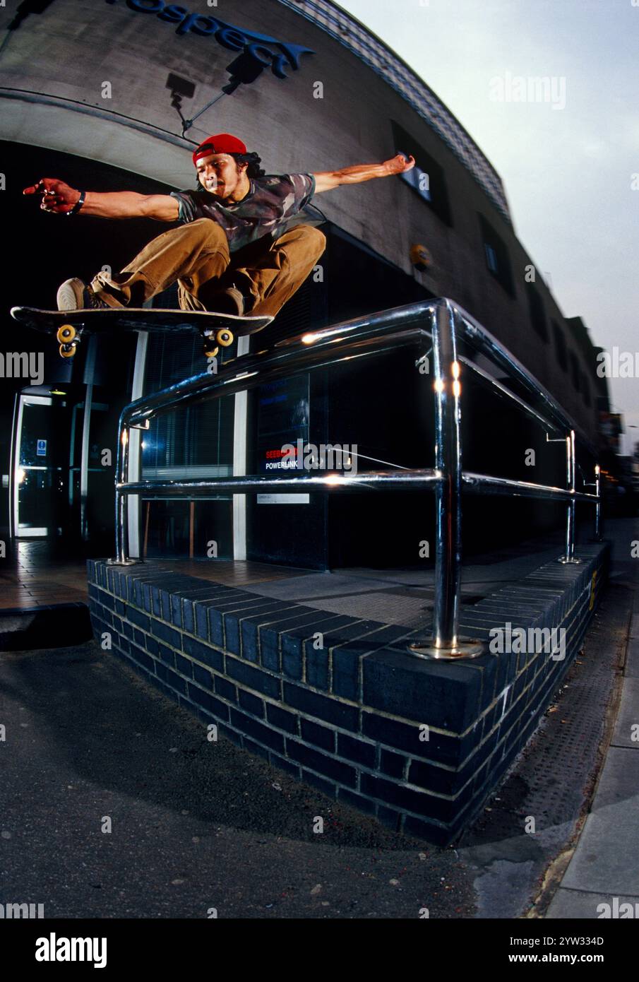 Skateborder springt über ein Metallgeländer. Stockfoto