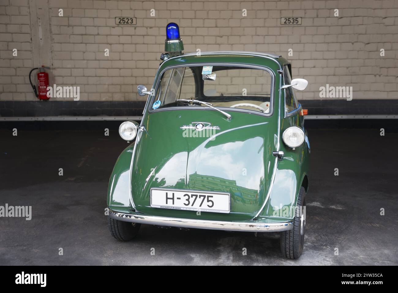 Grünes Vintage-Dreirad mit blauem Licht in Garage vor Backsteinmauer, BMW Isetta 300, Rollermobil, Polizeifahrzeug, Peine, Niedersachsen, Deutschland Stockfoto