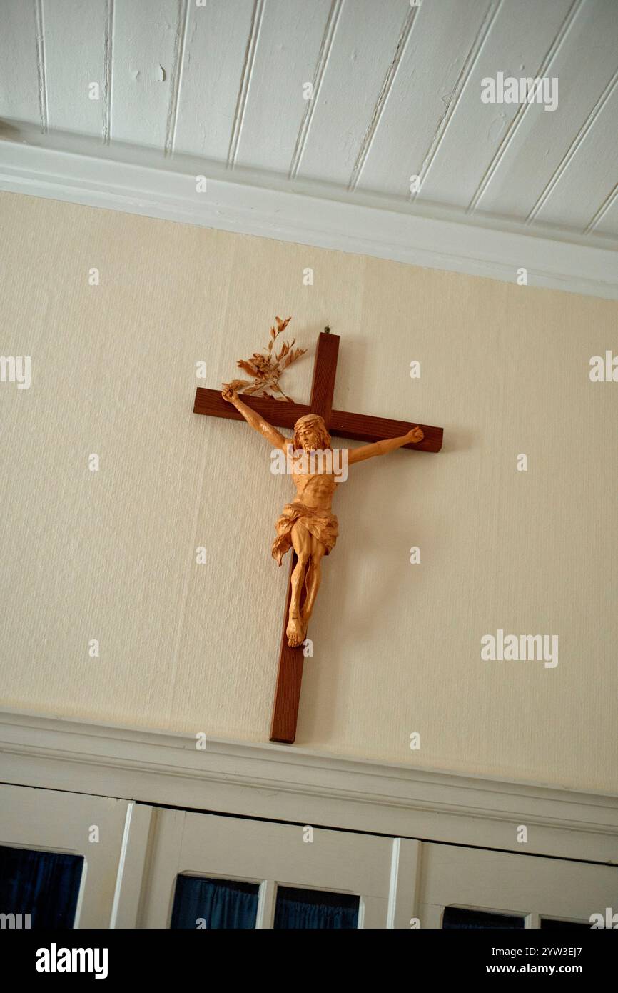 Hölzernes Kruzifix mit einer Jesusfigur auf einer weißen Wand unter einer Decke mit Balken, Mosel, Deutschland Stockfoto