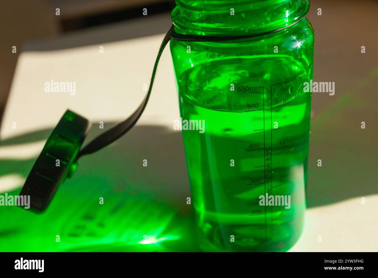 Wasser in einer Tritangrünen Flasche auf der Theke Stockfoto