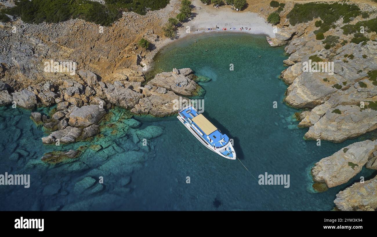 Palatia Beach, Palatia, Boot in einer kleinen Bucht mit kristallklarem Wasser und umliegenden Felsen, Bootstour Saria, Insel Saria, Karpathos, Dodekanese, Gree Stockfoto