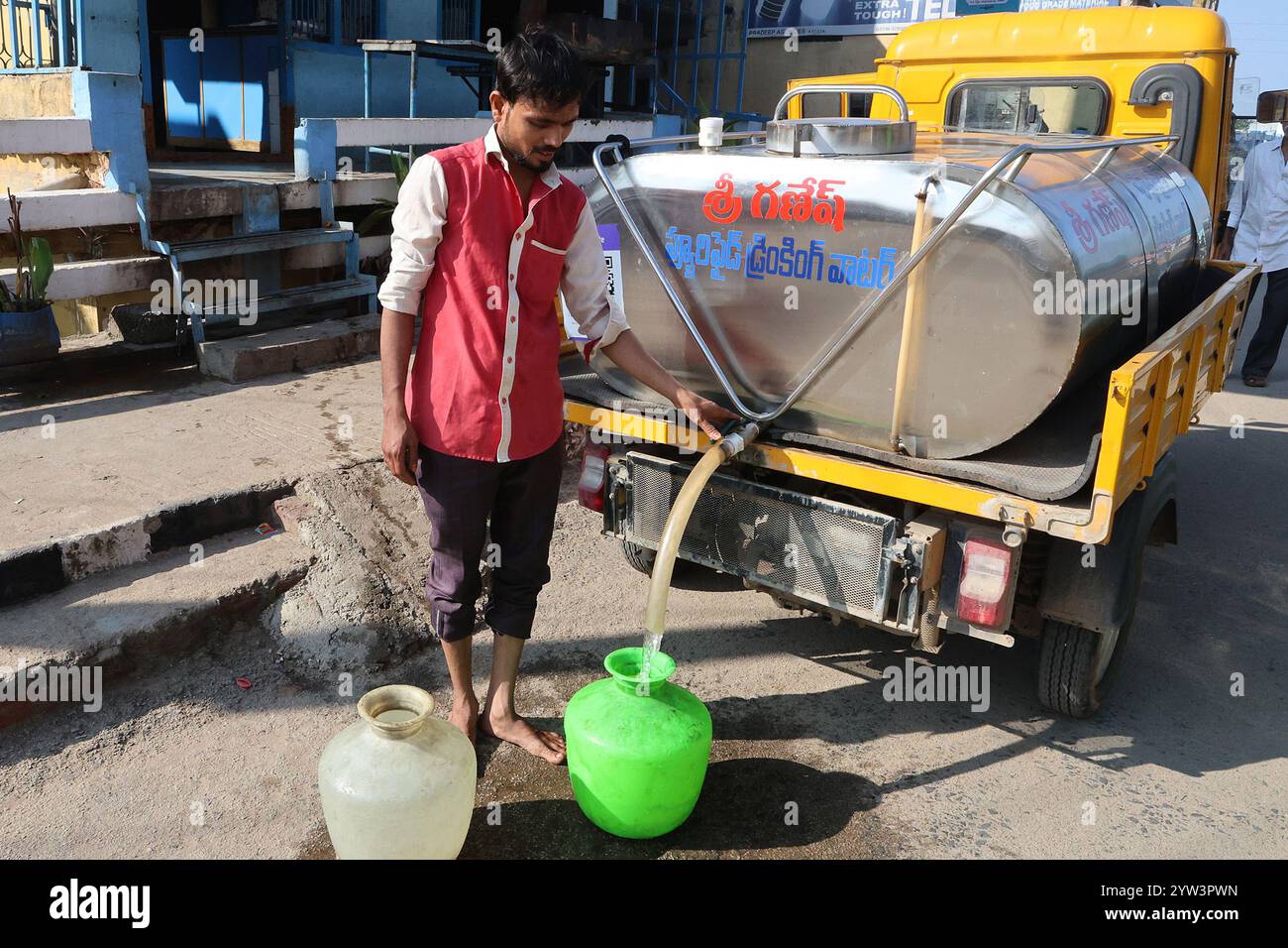 Füllen von Behältern mit Trinkwasser in Kadapa, Andhra Pradesh, Indien Stockfoto