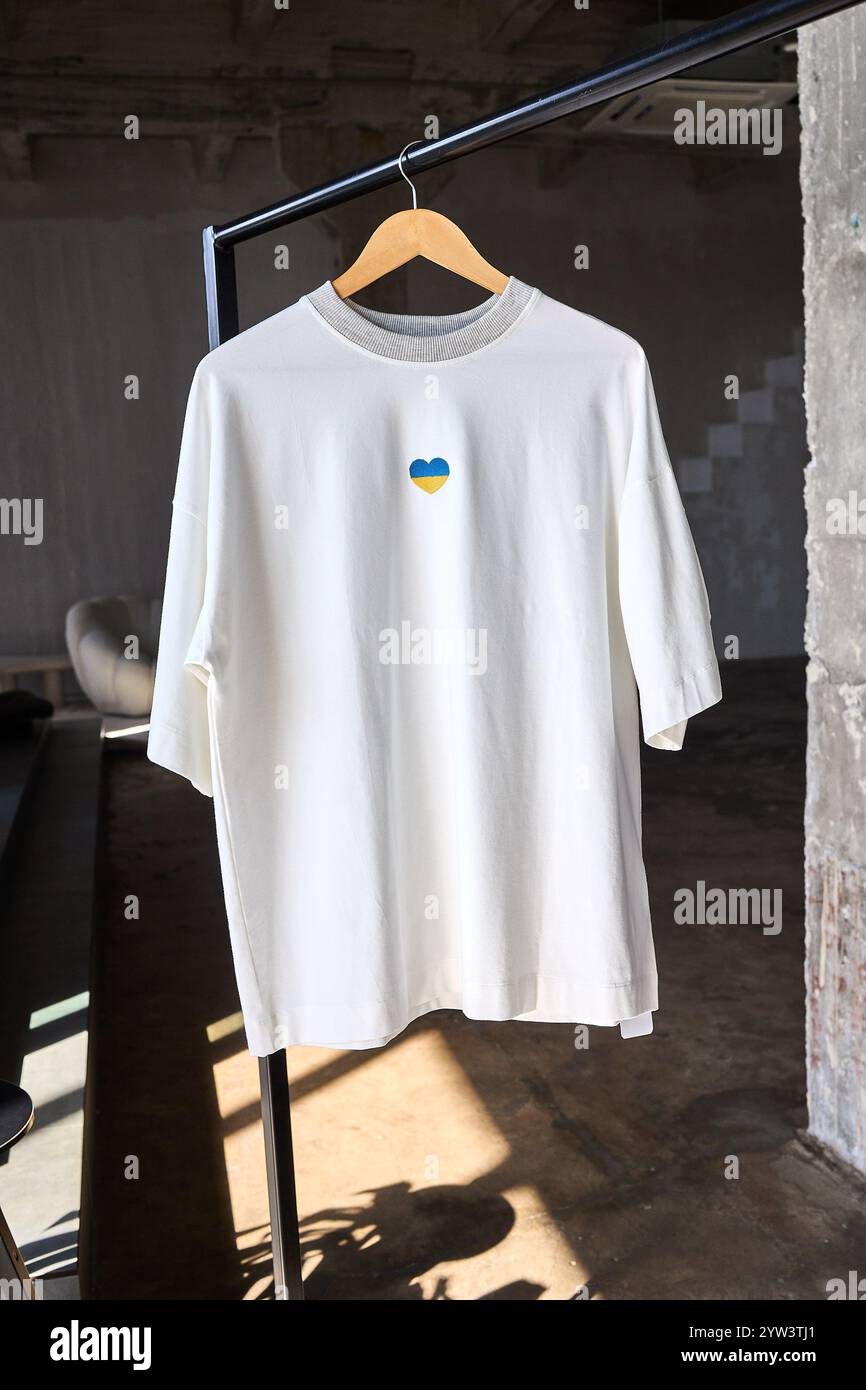 Weißes T-Shirt mit ukrainischem Herz auf einem Kleiderbügel Stockfoto