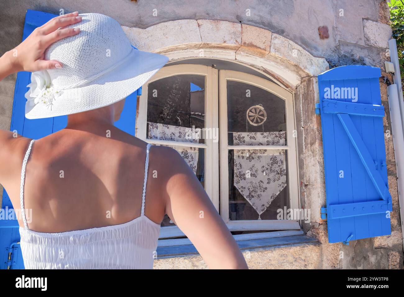 Frau im Sommerkleid im Urlaub, die auf die Fenster des Dorfes Gordes in Luberon, Provence, Frankreich blickt Stockfoto