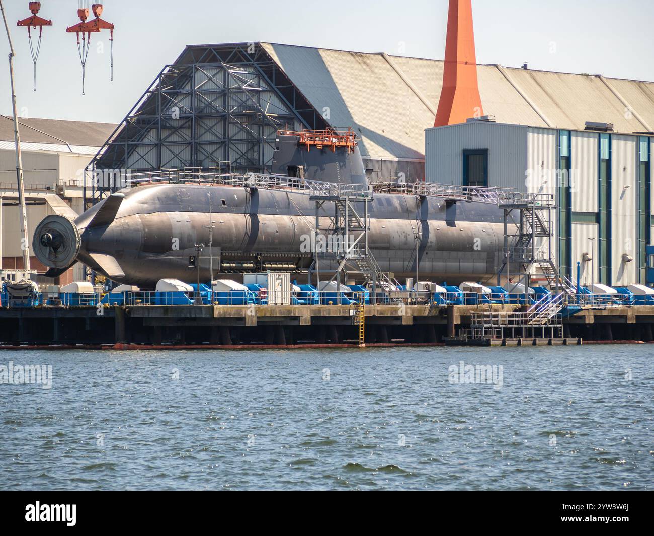 Hafenansicht in Kiel, Deutschland, mit einem U-Boot, das im Trockendock gebaut wird, und riesigen Gebäuden im Hintergrund. Stockfoto