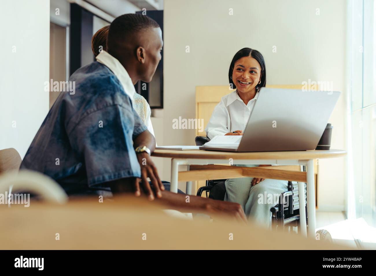 Eine Gruppe von Studenten, die in einem Lernzentrum zusammenarbeiten, an Diskussionen und Teamarbeit teilnehmen. Die Szene hebt die Vielfalt und die Einbeziehung eines Gestüts hervor Stockfoto