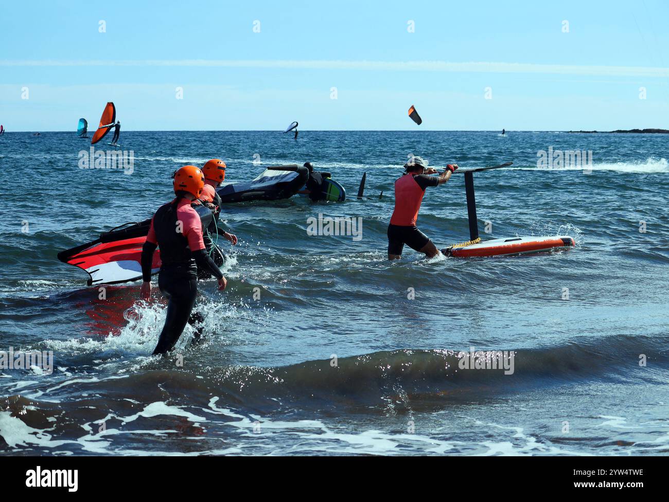 Schüler und Lehrer gehen im Meer, um den Surfkurs in Flügelfolie zu beginnen, Teneriffa, Spanien Stockfoto