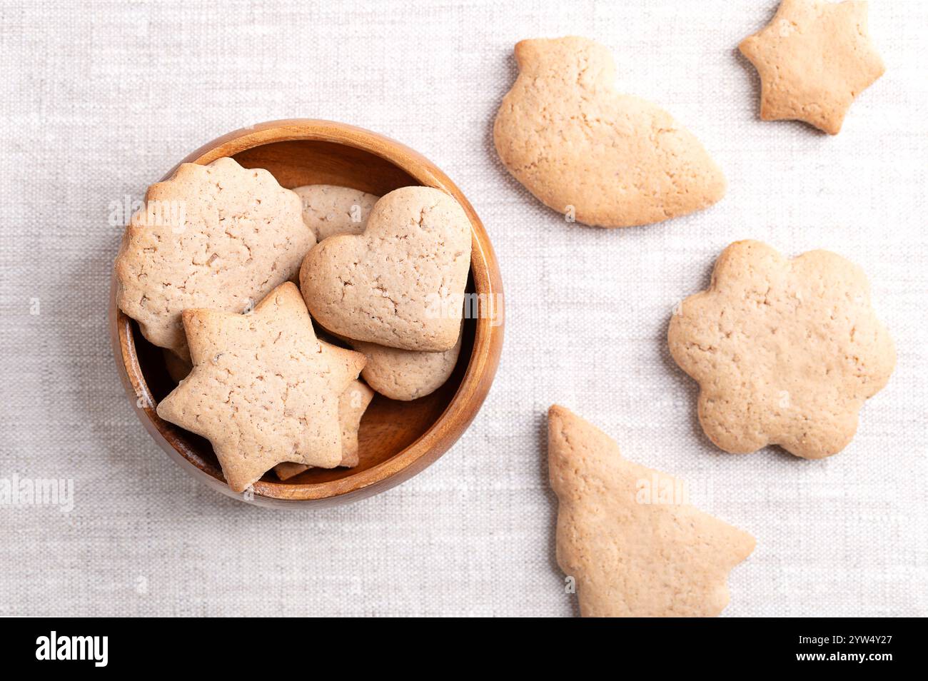 Hausgemachte Lebkuchenkekse in einer Holzschale auf Leinenstoff. Süße, hellbraune und flache Backwaren für die Weihnachtszeit. Stockfoto