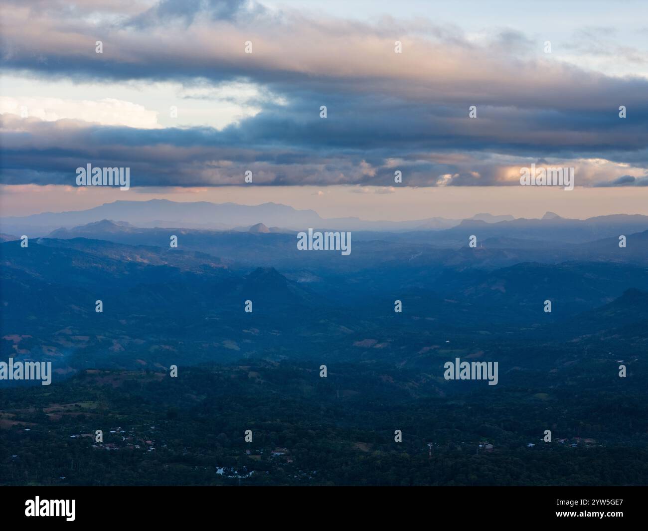 Weitläufige Berglandschaft, umgeben von Wolken und sanftem Dämmerlicht, schafft eine ruhige Atmosphäre. Stockfoto