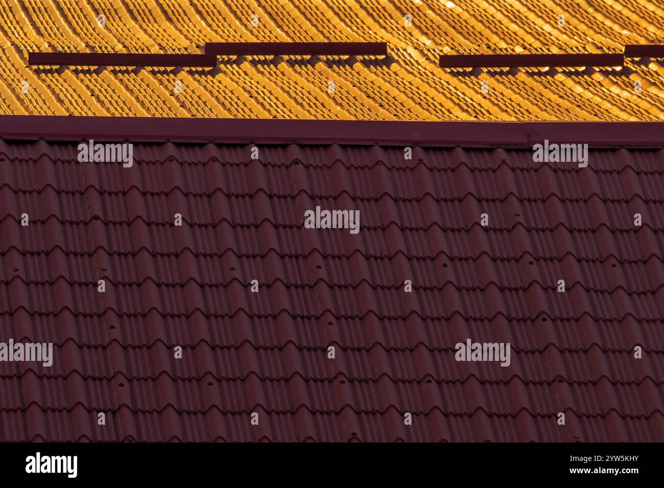 Geteilte Welten: Kontrast auf dem Dach bei Sonnenuntergang. Teil des Hauses. Stockfoto