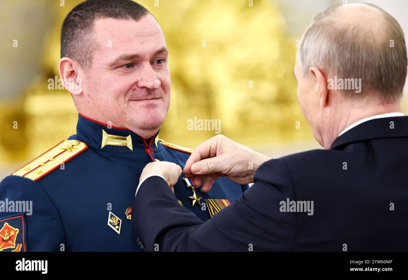 Moskau, Russland. Dezember 2024. Der russische Präsident Wladimir Putin überreichte die Goldstermedaille an den Helden von Russland, den Kommandeur einer Angriffseinheit, Captain Valery Enin, während einer Zeremonie zum Tag der Helden des Vaterlandes in der Halle des Großen Kreml-Palastes am 9. Dezember 2024 in Moskau, Russland. Quelle: Alexander Kazakov/Kreml Pool/Alamy Live News Stockfoto