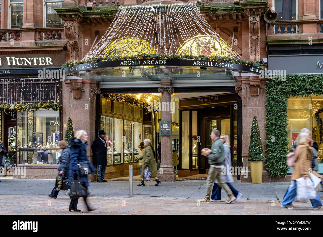 Weihnachtseinkäufer verschwimmen, als sie den Eingang zur Argyll Arcade in der Buchanan Street, Glasgow, Schottland, Großbritannien, Europa passieren Stockfoto