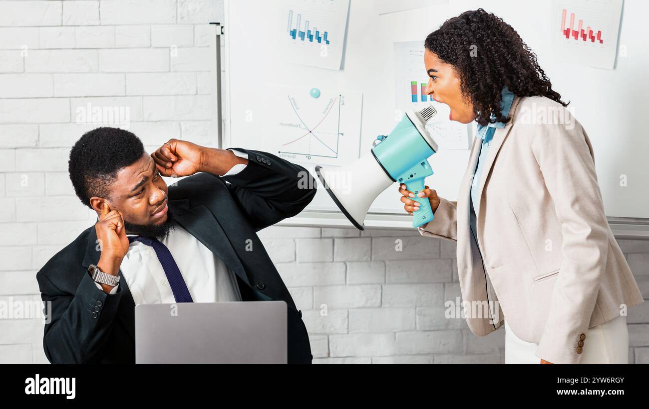 Erzürnte weibliche Chefin mit Lautsprecher schreit auf untergeordnete in der Firma Büro Stockfoto