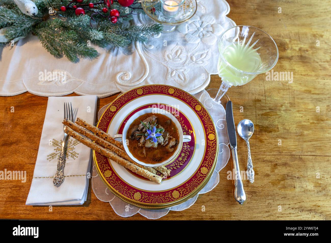 Enteneintopf und Brotstangen auf feinem Porzellan stellen Platz auf einem Weihnachtstisch. Stockfoto