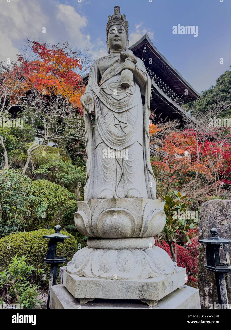Ruhige Kannon-Statue inmitten von Herbstlaub in einem japanischen Tempel Stockfoto