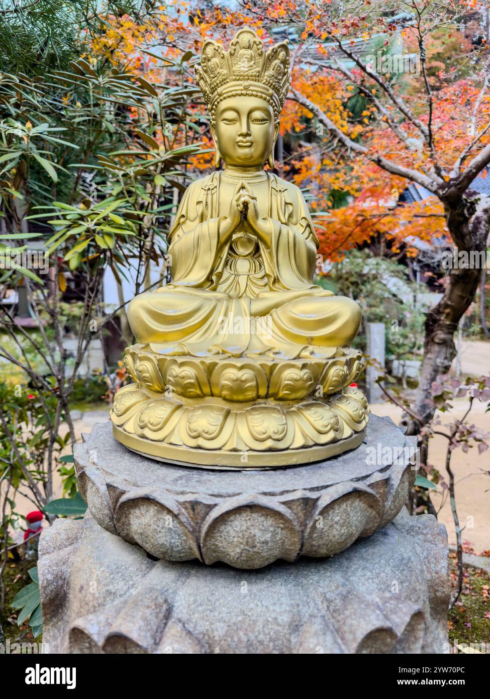 Goldene Buddha-Statue in einem lebendigen japanischen Garten Stockfoto