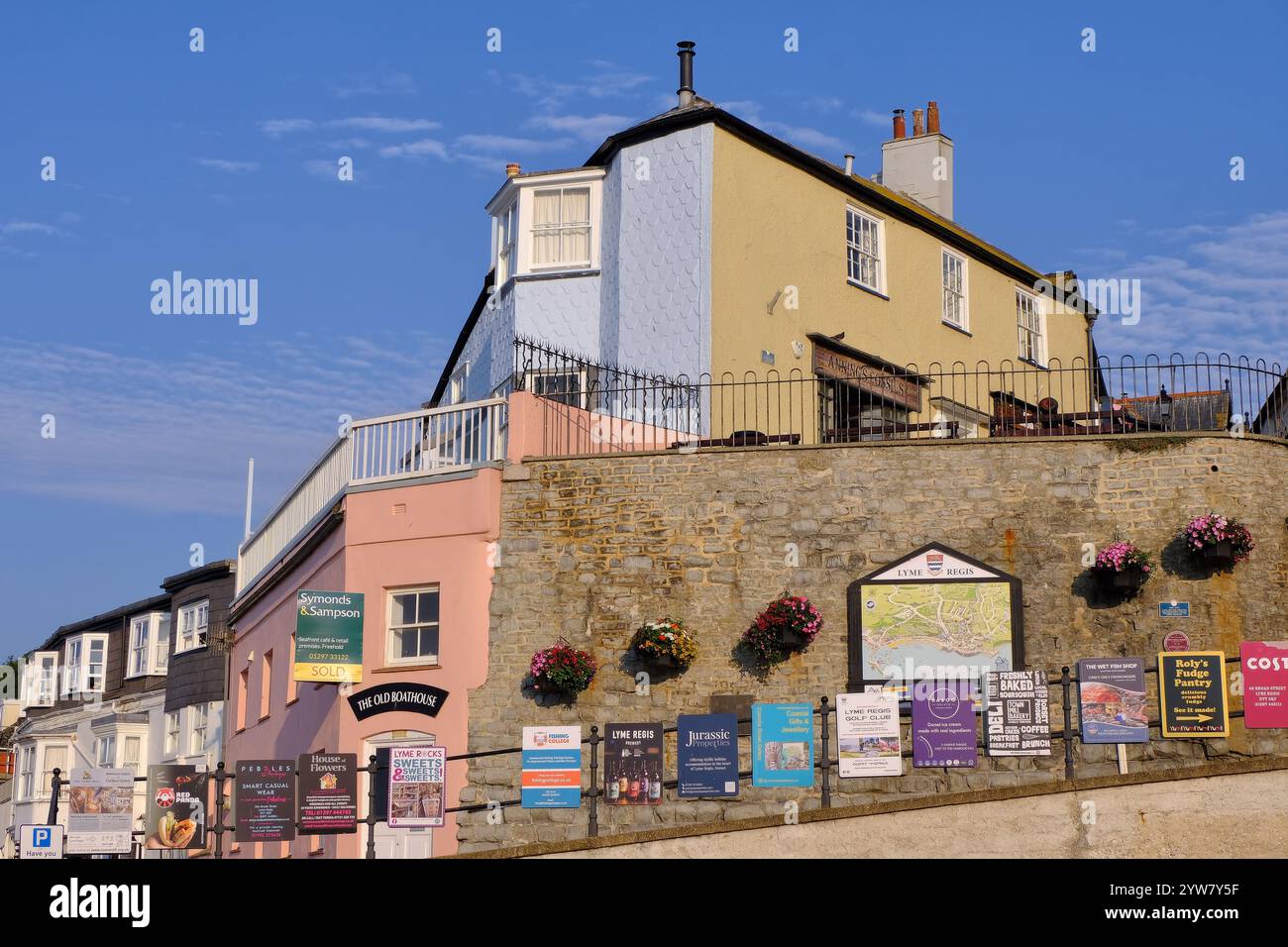 Lyme Regis: Lyme Regis: Pastellfarbene georgianische Gebäude und Anzeigen am Cobb Gate, Lyme Regis an der Grenze zu Devon Dorset, England Stockfoto
