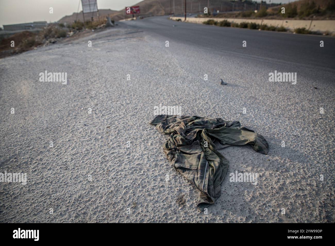 Verlassene Militäruniformen auf einer Straße außerhalb von Damaskus nach dem Sturz von Präsident Baschar al-Assad. Die Rebellen starteten Ende November in Syrien eine Schockoffensive, die Präsident Baschar al-Assad absetzte und mehr als ein halbes Jahrhundert des Assad-Familienregimes beendete. Stockfoto