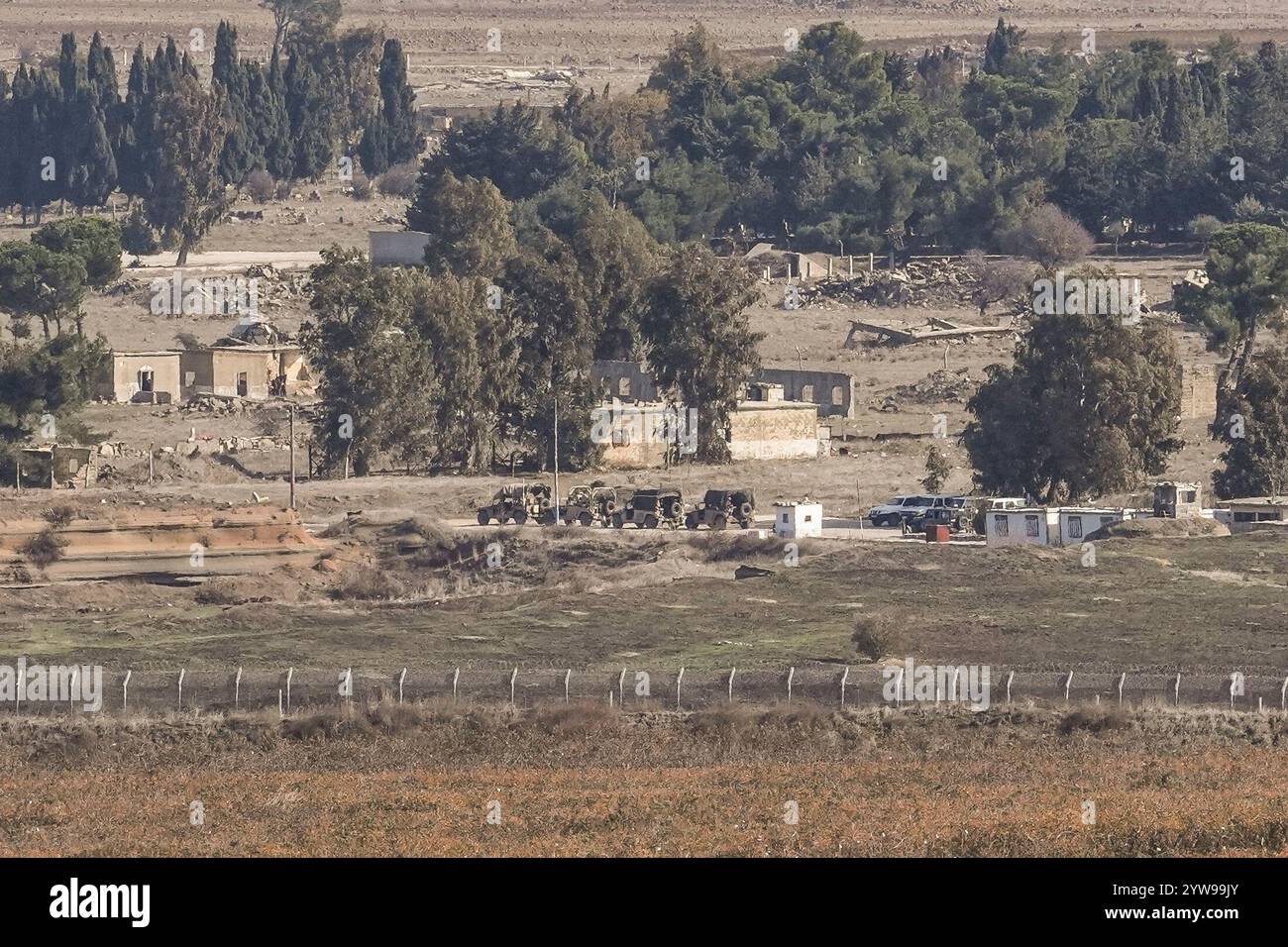 Israeli armored vehicles parked on the buffer zone in the Quneitra crossing, between Israel and Syria, are viewed from the Israeli-annexed Golan Heights, Tuesday, Dec. 10, 2024. (AP Photo/Matias Delacroix) Stockfoto