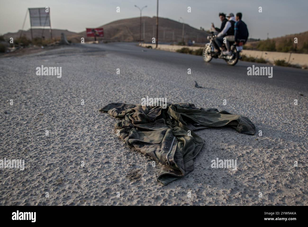 Damaskus, Syrien. Dezember 2024. Verlassene Militäruniformen auf einer Straße außerhalb von Damaskus nach dem Sturz von Präsident Baschar al-Assad. Die Rebellen starteten Ende November in Syrien eine Schockoffensive, die Präsident Baschar al-Assad absetzte und mehr als ein halbes Jahrhundert des Assad-Familienregimes beendete. (Foto: Sally Hayden/SOPA Images/SIPA USA) Credit: SIPA USA/Alamy Live News Stockfoto