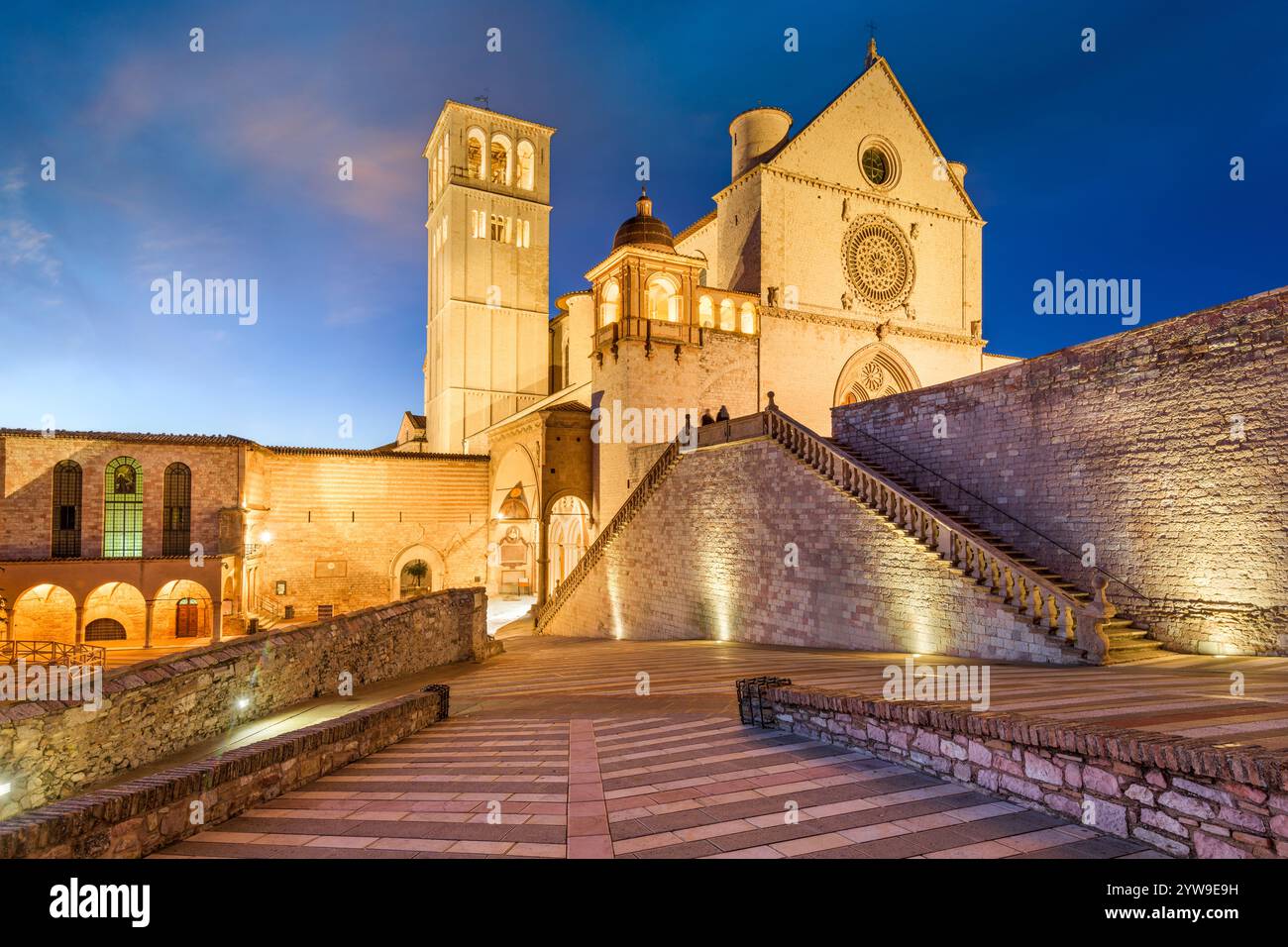 Assisi, Italien mit der Basilika des Heiligen Franziskus von Assisi in der Abenddämmerung. Stockfoto