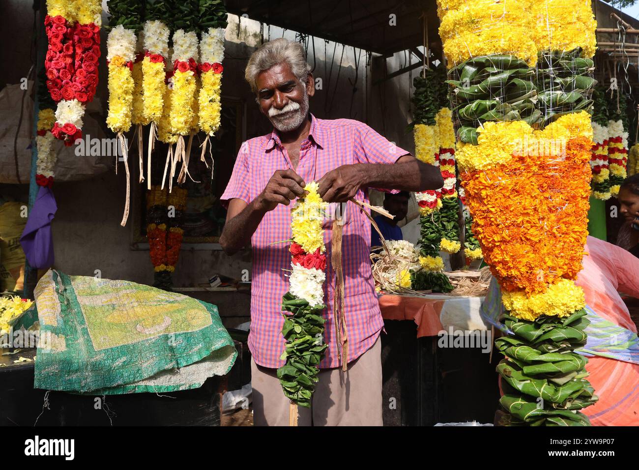 Blumenhändler, der Girlanden herstellt in Tirupathi, Andhra Pradesh, Indien Stockfoto