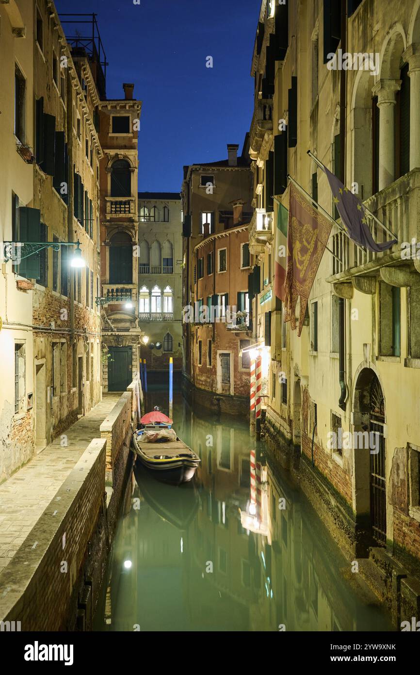 Blick auf eine Wasserstraße mit einem Boot, das im Wasser liegt, in Venedig bei Nacht im Winter, Italien, Europa Stockfoto