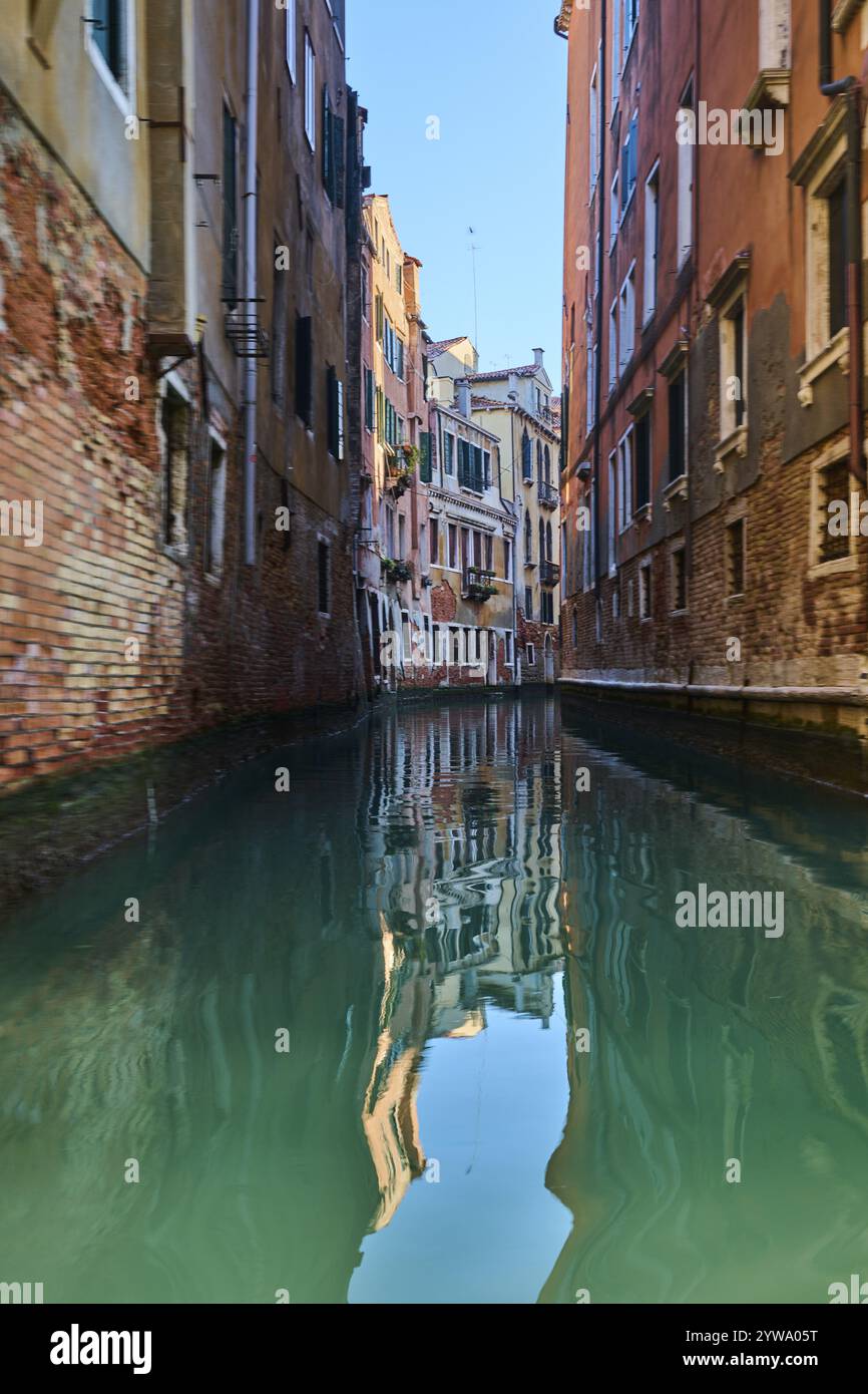 Blick von einer Gondel auf einer Wasserstraße in Venedig durch die Häuser an einem ruhigen und sonnigen Morgen im Winter, Italien, Europa Stockfoto