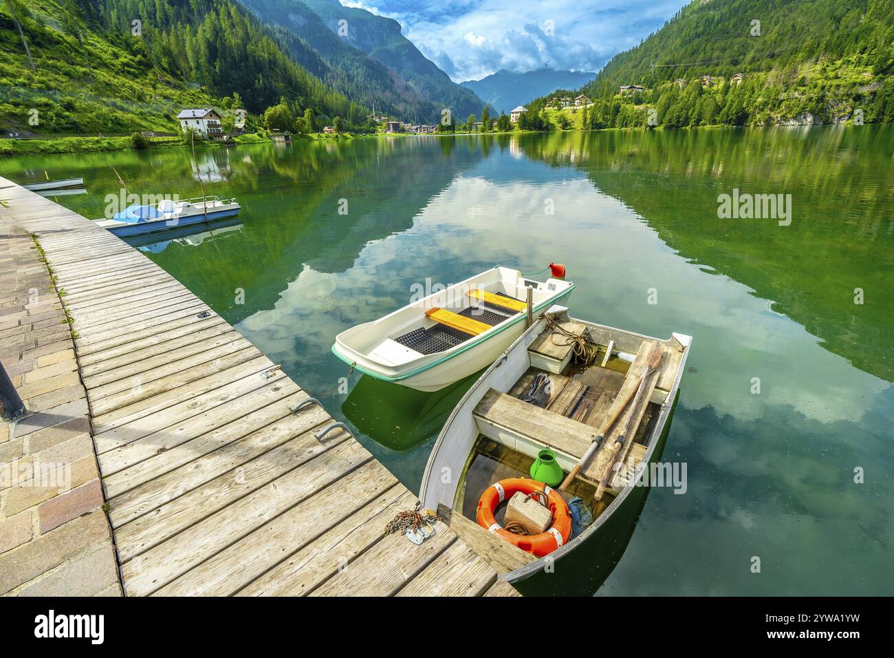 Holzpier mit Booten, die sich im smaragdgrünen Wasser des alleghe-Sees spiegeln, mit den dolomiten im Hintergrund, italien Stockfoto